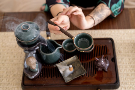 Chinese traditional drink. Tea ritual. Female hand preparing ceremony enjoying meditation aromatherapy vapor spiritual enlightenment.の写真素材