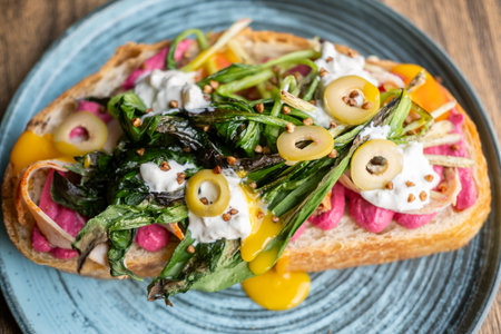 Breakfast served. Delicious bruschetta. Healthy veggie toast with beetroot food. Runny creamy sauce with grilled greens herbs on bread.の写真素材