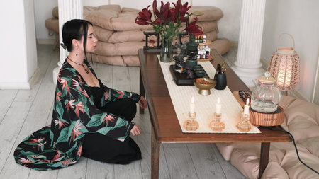 Female meditation. Spiritual zen. Inspired girl cross-legged practicing yoga enjoying aromatherapy candles calming peaceful indoor.の写真素材