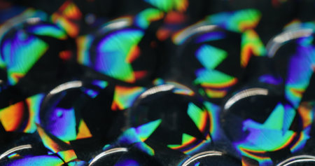 Defocused glow rainbow. Colorful light. Orange blue green round reflection gleam texture leak on abstract dark black art background.の写真素材