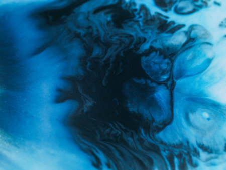 Ink flow defocused. Watercolor drop. Black wave pigment spill on blue liquid background. Dark dye abstract dissolving in art color emulsion.の写真素材