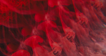 Blur fume explosion. Ink blob. Bright red color dye dissolving underwater. Art kaleidoscopic prism drip trickles on abstract background.の写真素材