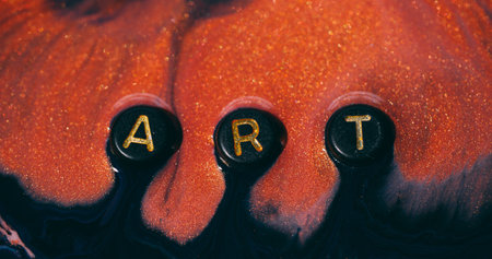 Art glitter. Paint word. Defocused orange yellow purple color sparkling drip particle black texture...