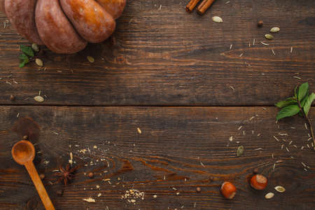 Wooden table with pumpkin and spices flat lay. Top view on rustic workplace with ingredients for preparing squash meal, free space. Kitchen, recipe, cooking backgroundの写真素材