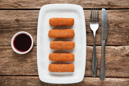 American fast food. Fried chicken nuggets on white plate served with tasty sauce and cutlery on...