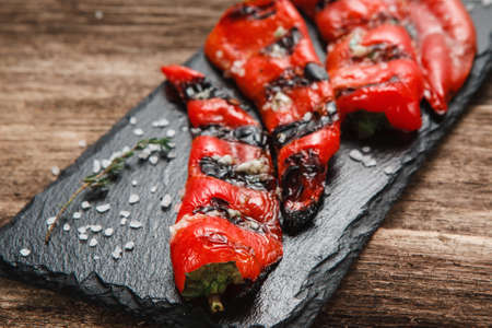 Tasty and juicy grilled pepper served on black slate, close up view. Menu photo. Vegetarian food, healthy eating conceptの写真素材