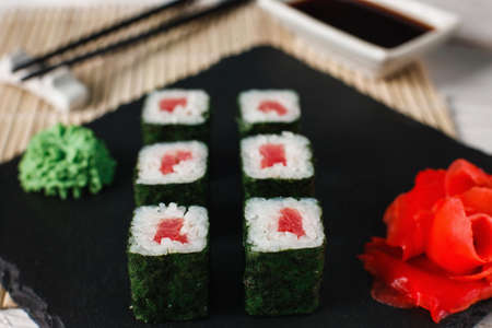 Delicious, fresh and tasty sushi rolls set with tuna served on black slate, close up. Japanese seafood, maki.の写真素材