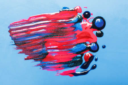 Creativity, modern abstract painting, art. Bright shiny texture of blue, red and black sparkling nail polish on blue background.の写真素材