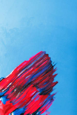 Creativity, modern art, creative abstract painting. Sparkling and shiny smudge nail polish on blue background, with free space for text.の写真素材