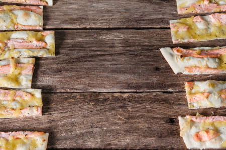 Traditional italian fast food background. Delicious pieces of hot seafood pizza, frame on rustic wooden table with free space for text, flat lay.の写真素材