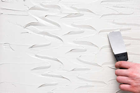 Spatula Hand White Plaster Texture Background Repair Construction Stucco Design Conceptの写真素材