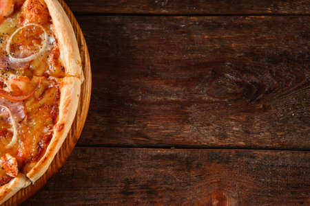 Fresh baked pizza served on rustic wooden table with free space for text. Italian national fast food background, flat layの写真素材