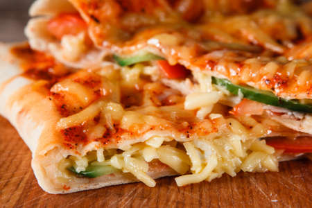 Closeup of fresh baked appetizing slices pizza calzone. Italian traditional food, restaurant menu...