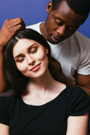 Black man caress white woman hair, closeup. Interracial relationship, international couple in love, tenderness, soft touch, happiness concept.の写真素材
