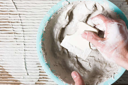 Builder dirty hand mix plaster with white spatula, flat lay. Repair work, construction, decoration...