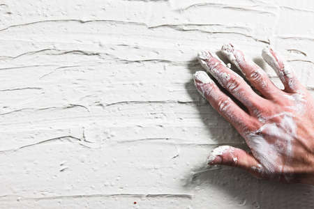 Worker Hand Stucco Plaster Wall Building Background Flat Lay Construction Repair Dirty White Conceptの写真素材