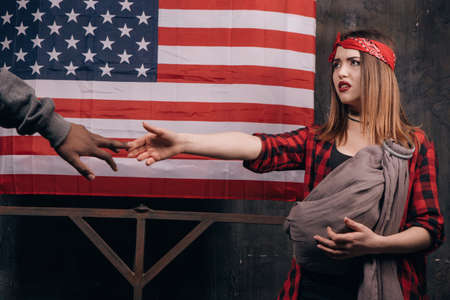 Child without a father. Break of family relations. Sad wife and husband on USA national flag background. Divorce, social problem, father leaving, youth pregnancy conceptの写真素材