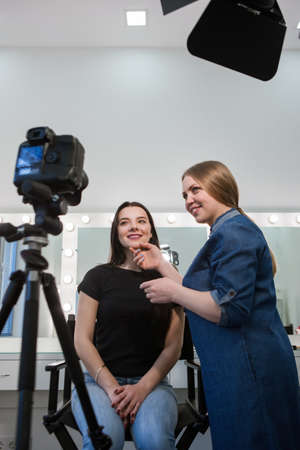 Beautician blogger work on camera. Cheerful women looking at makeup result making a beauty blog.の写真素材