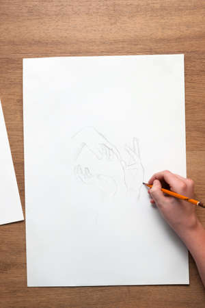 From above unfecognizable person drawing sketch with hands with pensil. Drawing lessons, art school, young artist conceptの写真素材