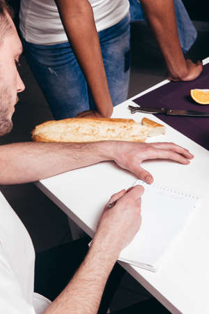 Young couple plans the future and writes a to-do list in notebook. Trust, family values, brainstorming, achieving goals, inspiration, startup conceptの写真素材