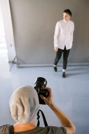 Photographer and model during studio session. Unrecognizable man taking shot of male model in studio. Photo school, lookbook, fashion backstage conceptの写真素材