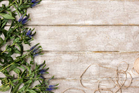 Workplace with wildflower decor flat lay. Floristry workshop wooden table with decor. Decorative artwork from spring flowerの写真素材