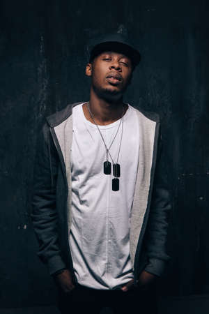 Dangerous drug addict black man stay on dark background. American gangster, dangerous people, urban style conceptの写真素材