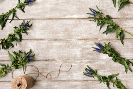 Workplace with wildflower ornament flat lay. Floristry workshop wooden table with decor. Decorative artwork from spring flowerの写真素材