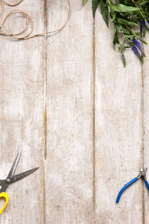 Workplace of decorator, florist. Flat lay professional tools. Floristry workshop wooden table with decor. Decorative artwork from spring flowerの写真素材