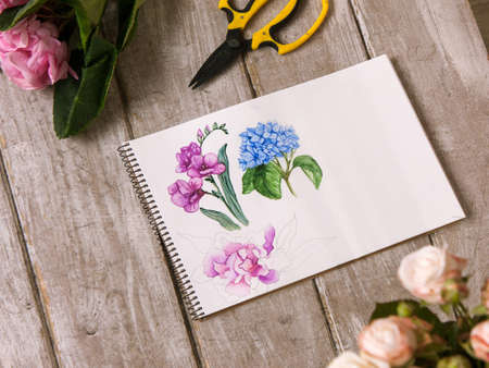 Workplace of decorator, florist. Sketch of flower top view. Professional tools. Floristry workshop wooden table with decor. Decorative watercolor artworkの写真素材