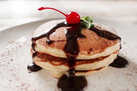 American breakfast. Pancakes with chocolate on white restaurant plate. Cafe menu, sweet food, crep...