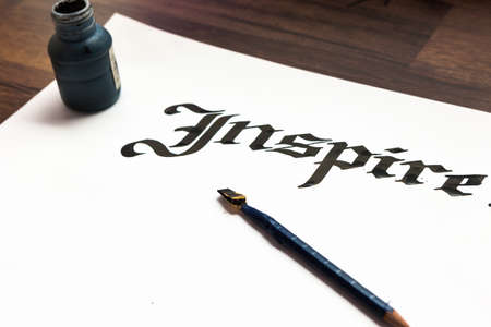 Writers tools. Ink, paper, pen top view. Inspire calligraphy lettering background. Word drawn with inks on sheet of paper. Drawing lessons, art school, creativity conceptの写真素材