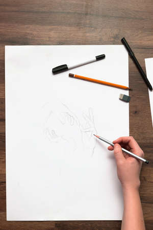 Unrecognizable painter draws hands flat lay. Top view of process of creation new picture, art school, young artist workplace conceptの写真素材