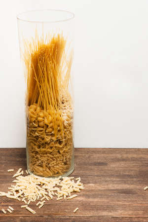 Pasta mix in jar on table on white background. Messy kitchen, culinary ingredient conceptの写真素材
