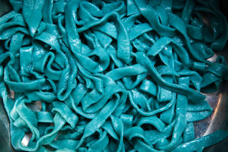 Colorful cooked tagliatelle closeup. Blue fettuccine top view culinary backgroundの写真素材