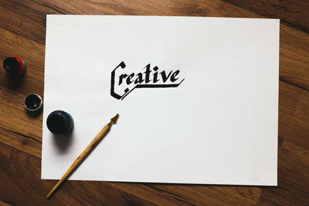 Creative artist workplace. Ink handwritten word and pen top view. Painter workshop, art business inspiration, creativity, handmade drawing conceptの写真素材