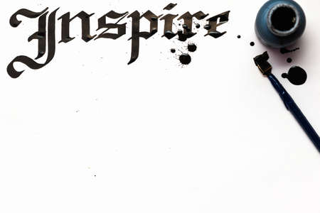 Inspire calligraphy lettering background. Word drawn with inks on sheet of paper. Drawing lessons, art school, creativity conceptの写真素材