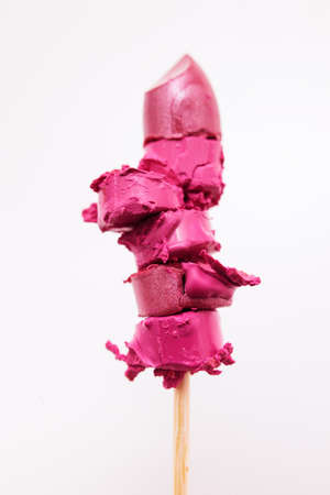 Chopped pink lipstick on stick. Cosmetics commercial, creative advertising, interesting ice cream,...