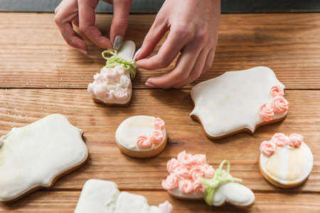 Wedding gingerbread decorated with ribbon by baker. Tasty food closeup, sweet dessert on wooden background top view. Baking conceptの写真素材