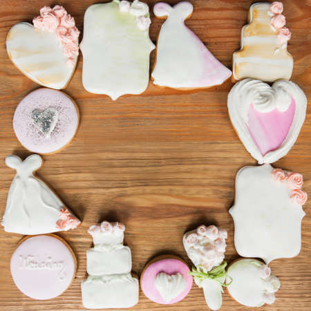 Many gingerbread make square frame on wooden background. Wedding present top view, beautiful cookies closeup, food conceptの写真素材