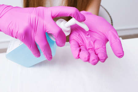 Disinfection hands before manicure in the salon closeup. Beautician is disinfecting her palms with disinfectantの写真素材