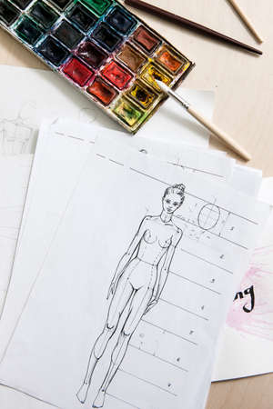 Fashion model sketch with watercolor paint on designer workplace