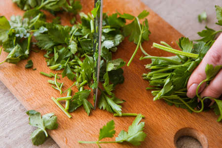 Chopped parsley on wooden desk, close up picture. Herbs as healthy and organic food using in cooking and culinary artの写真素材
