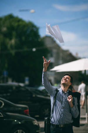 Happy young man took vacation. Joyful and free businessman on streetの写真素材