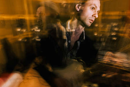 Guitarist creative portrait in double exposure. Music recording studio, split personality, dark psychological conditionの写真素材