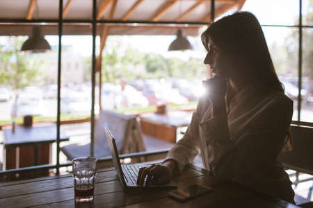 Lunch break during work. Freelancer in cafe. Modern social media, thoughtful business ladyの写真素材