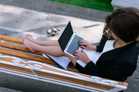 Secretary at remote job. Student typing outdoors. Young girl doing business documentation top viewの写真素材