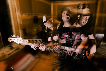 Recording studio background. Music band rehearsal. Adult male guitarist portrait in garage, split...