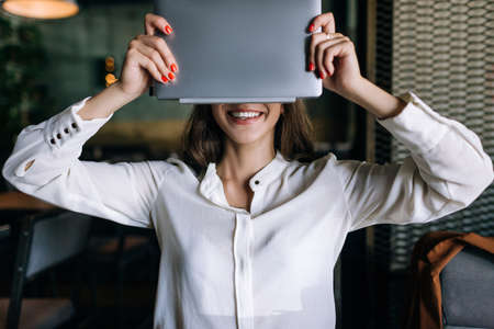 Anonymity in Internet. Modern technology. Electronic purchase, success in e-commerce, business woman hiding faceの写真素材