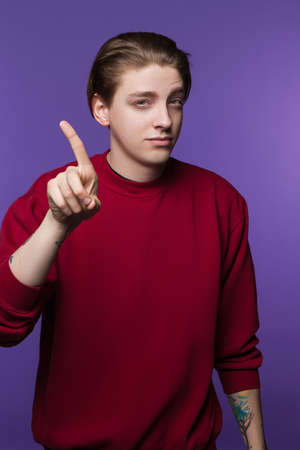 Refusing young male. Deny involvement. Handsome suspicious man with hand gesture, protest conceptの写真素材